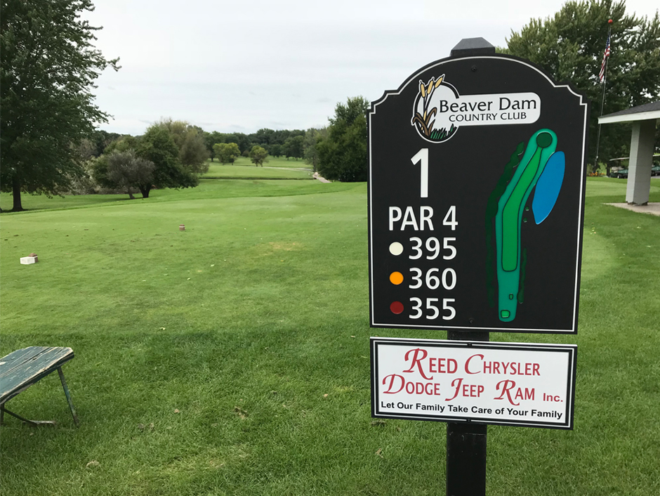 sign shown with local advertising on golf course